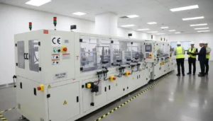 Industrial aluminium foil cutting machine with workers in a modern factory setting, showcasing advanced technology and